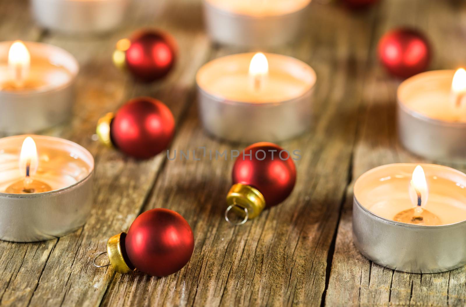 Advent and Christmas candlelights with red balls on wooden table