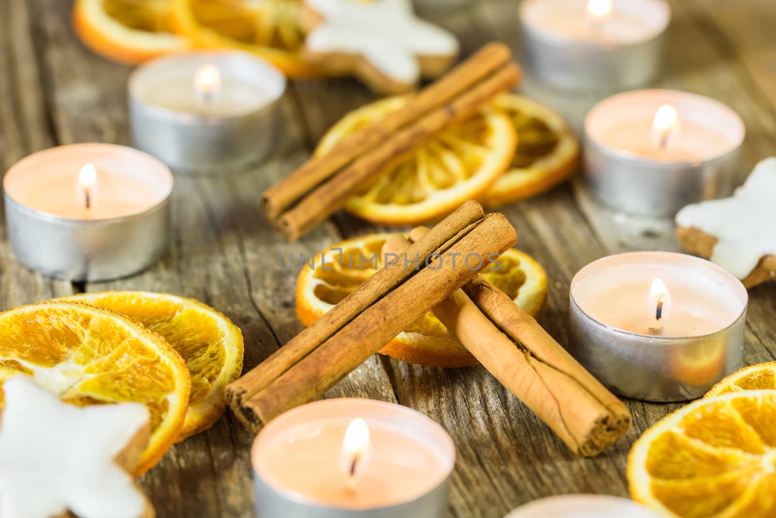 Advent and Christmas season composition with candle flames, orange slices, cinnamon and star shape cookies