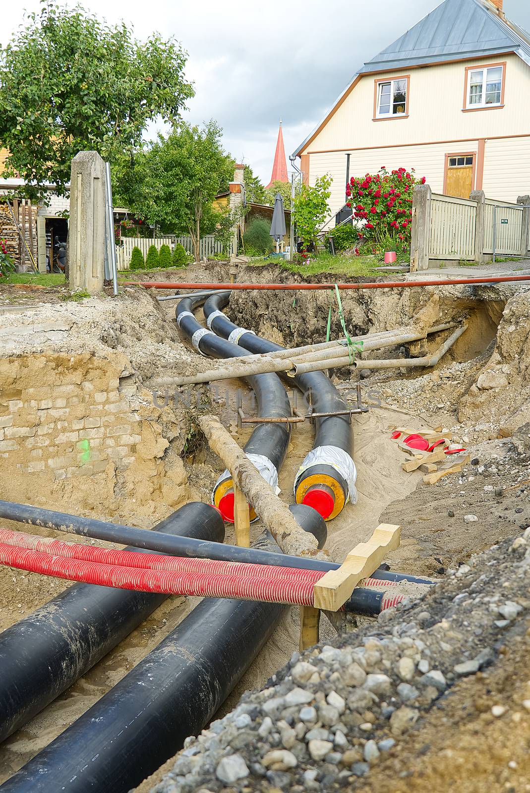underground heating system pipes replacement on the city street among the houses