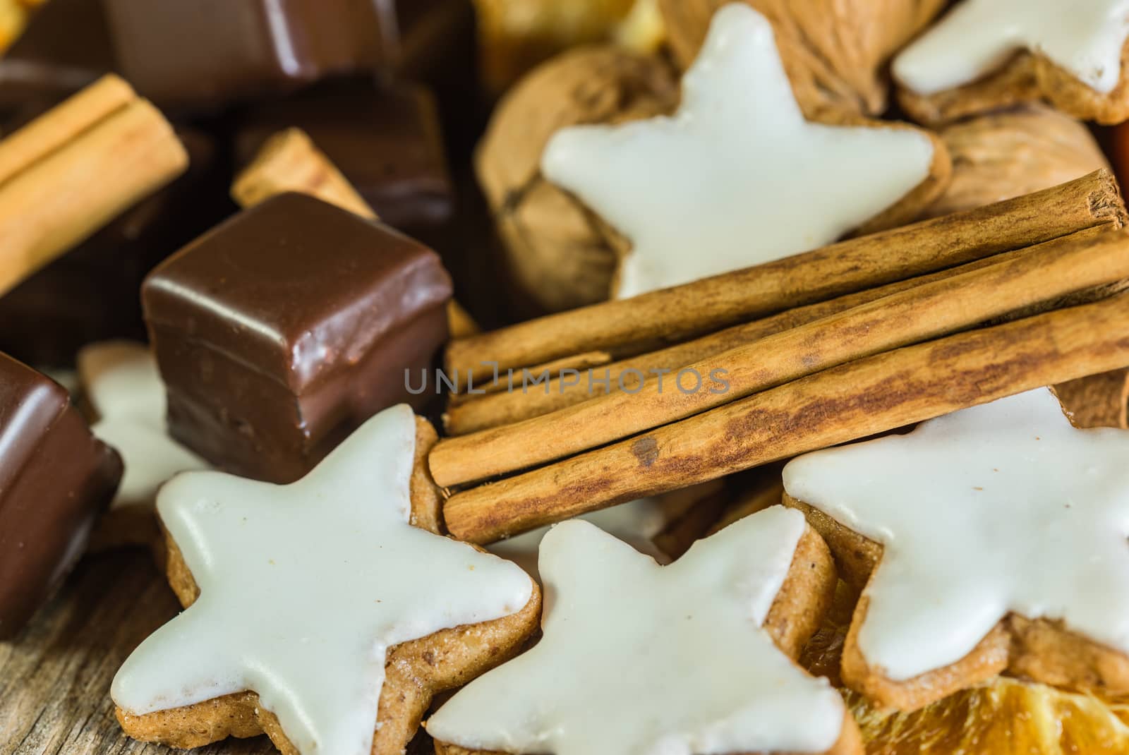 Star shape cookies, chocolates, nuts and cinnamon, Christmas food 