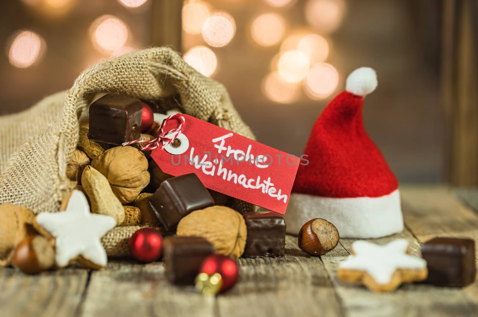 Christmas or Advent food and sweets background with tag and german text, Frohe Weihnachten, means Merry Christmas