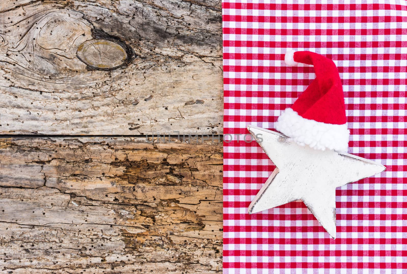 Amusing Christmas decoration, white wooden star shape with red Santa Claus cap