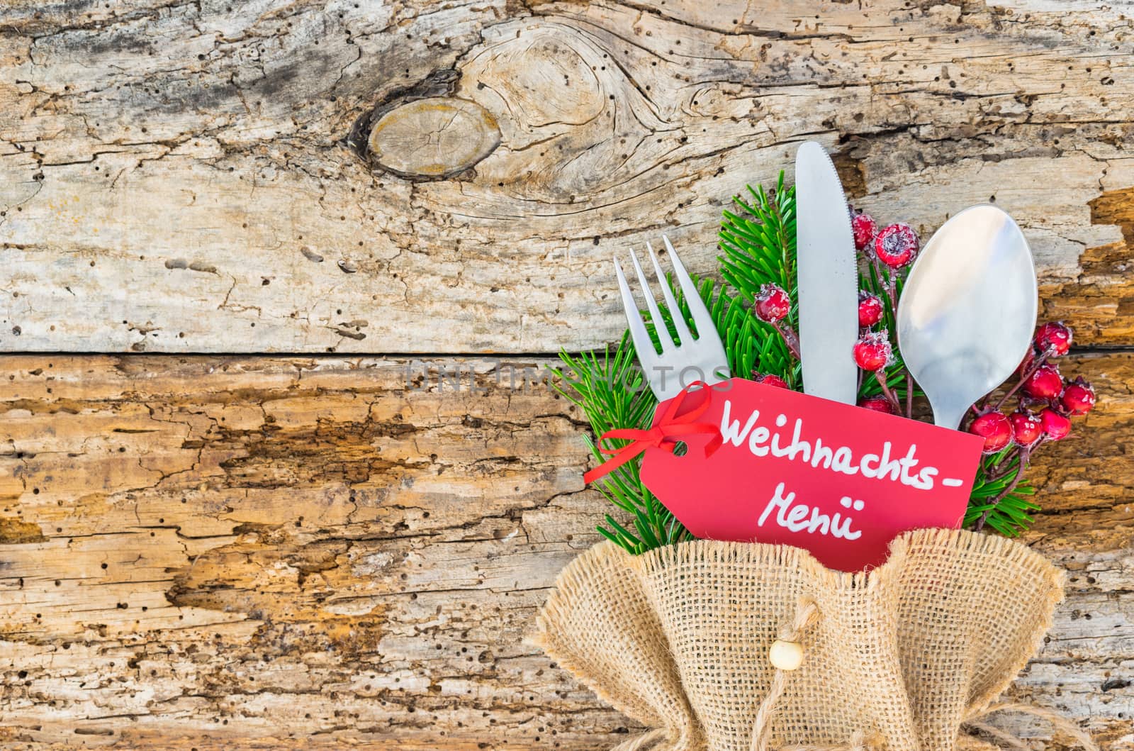 Christmas table place setting with  menu tag and german text, Weihnachts-Menue, means christmas menu