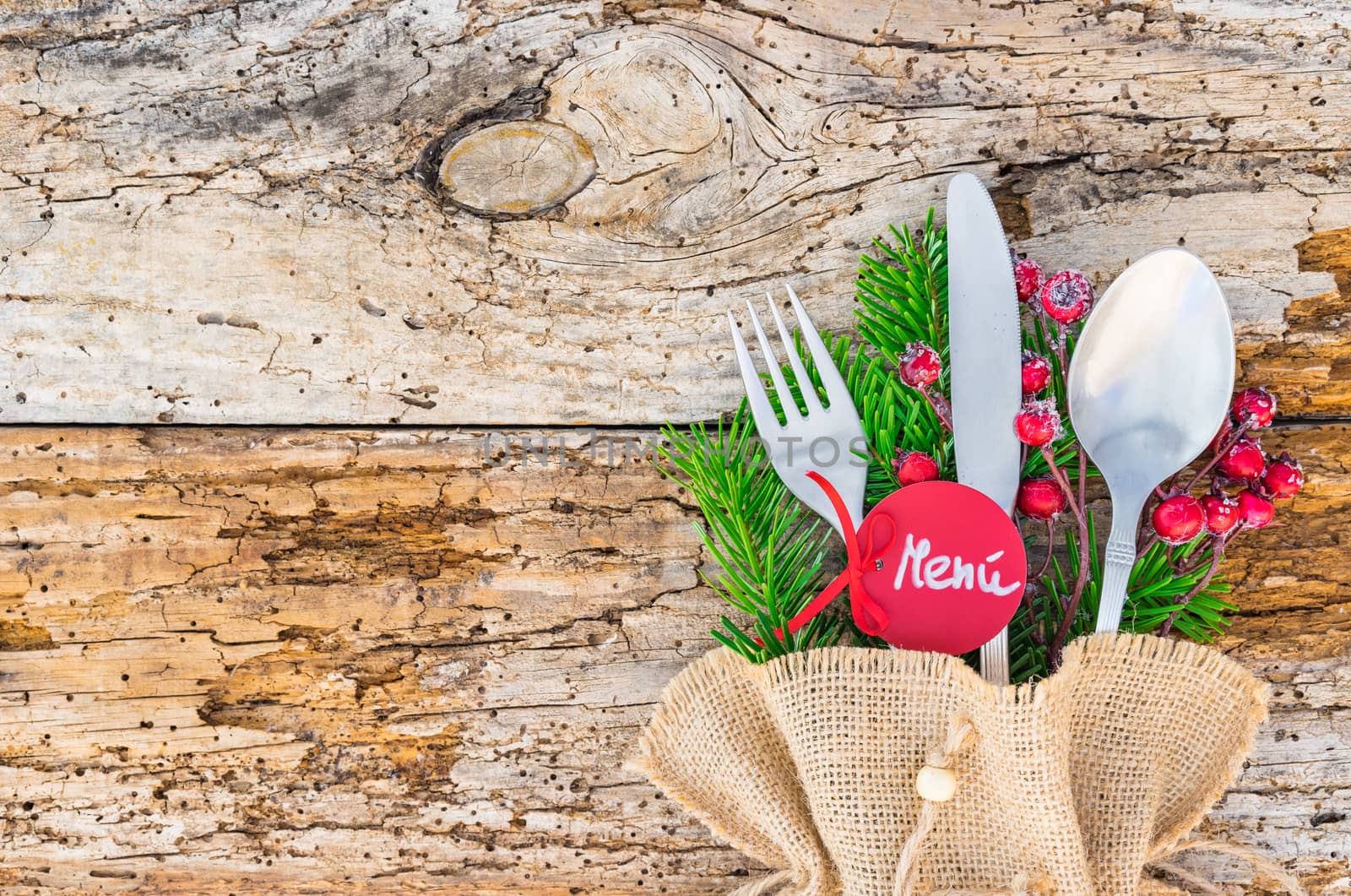 Christmas cutlery on wooden table background with spanish menu tag, menú means menu 