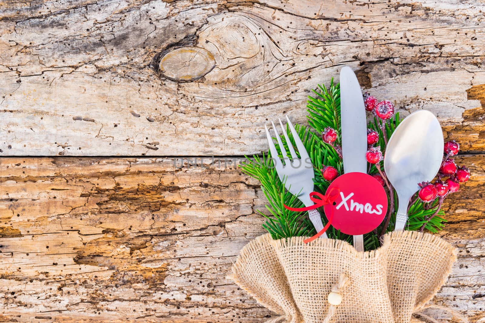 Rustic silverware for Christmas dinner, with tag xmas, and empty space for text on wood