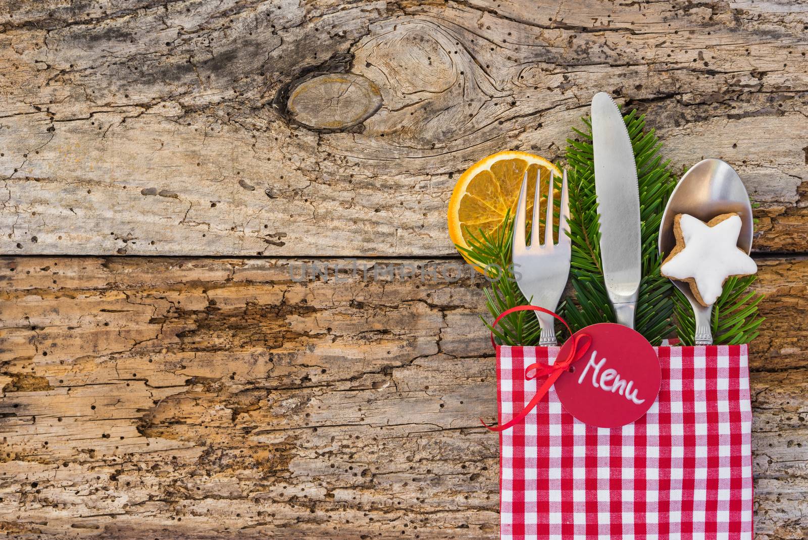 Christmas dinner meal cutlery with napkin on rustic wooden table, place setting background