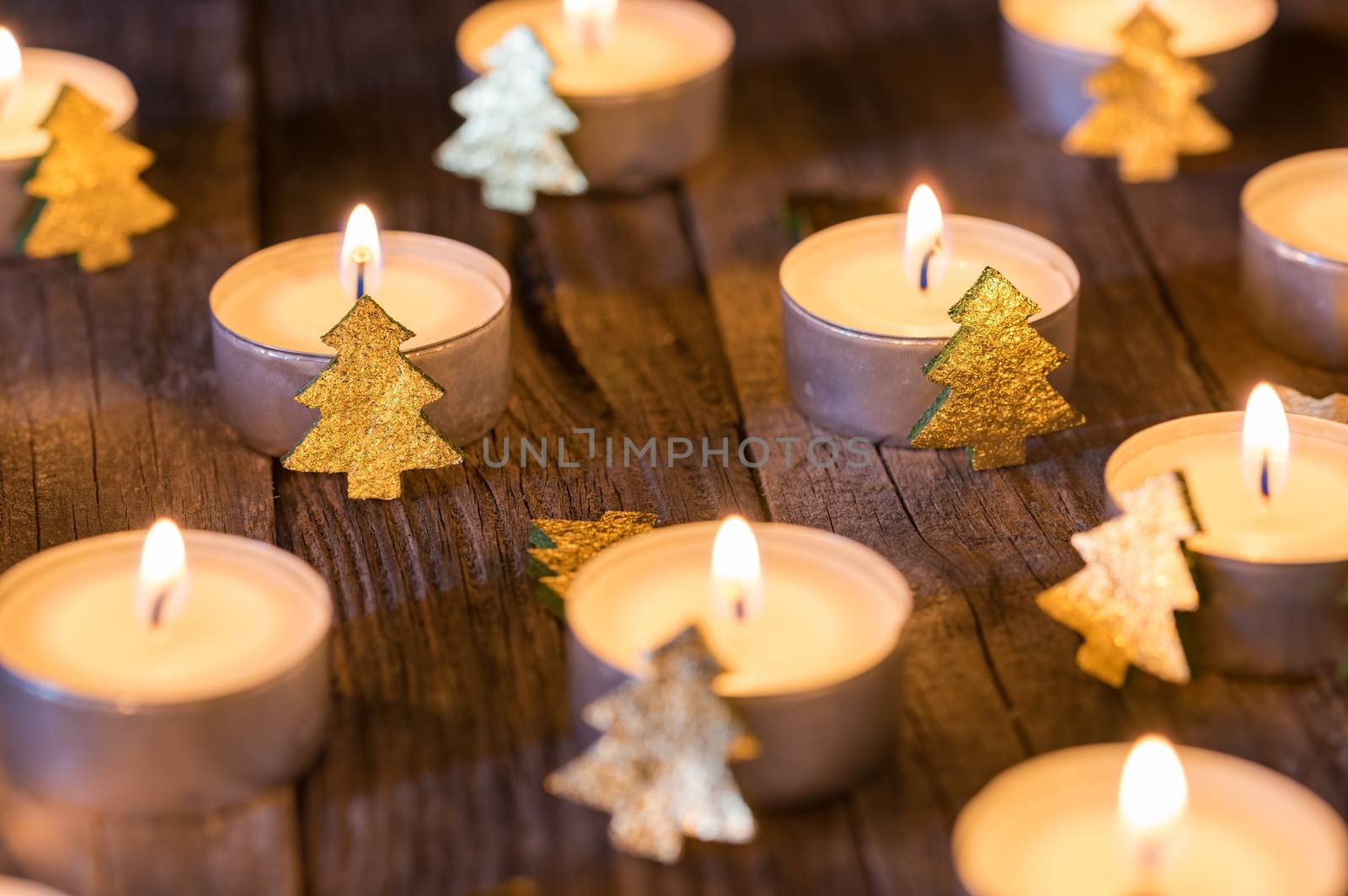 Burning christmas candles with golden christmas trees ornaments decoration