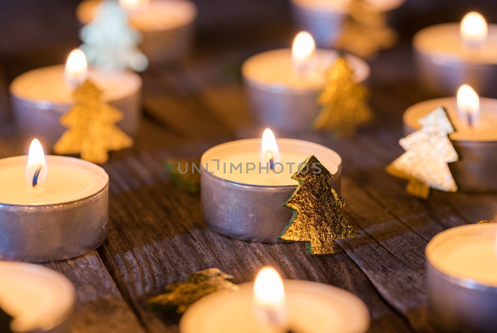 Christmas candlelight ornate with golden xmas trees on wooden table by Vulcano