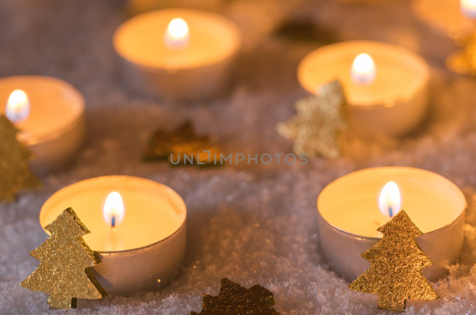 Christmas winter night with candle flames and ornaments on snow