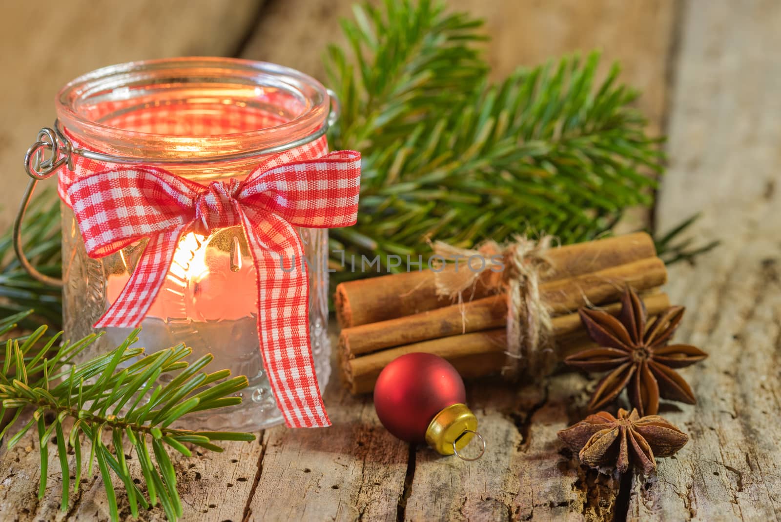 Burning candle in Christmas lantern with decorations by Vulcano