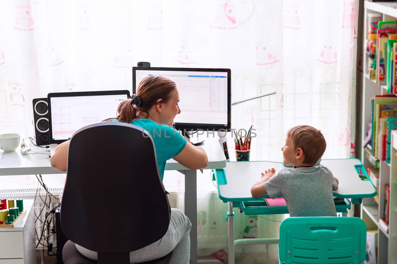 Mother with kid trying to work from home during quarantine. Stay at home, work from home concept during coronavirus pandemic