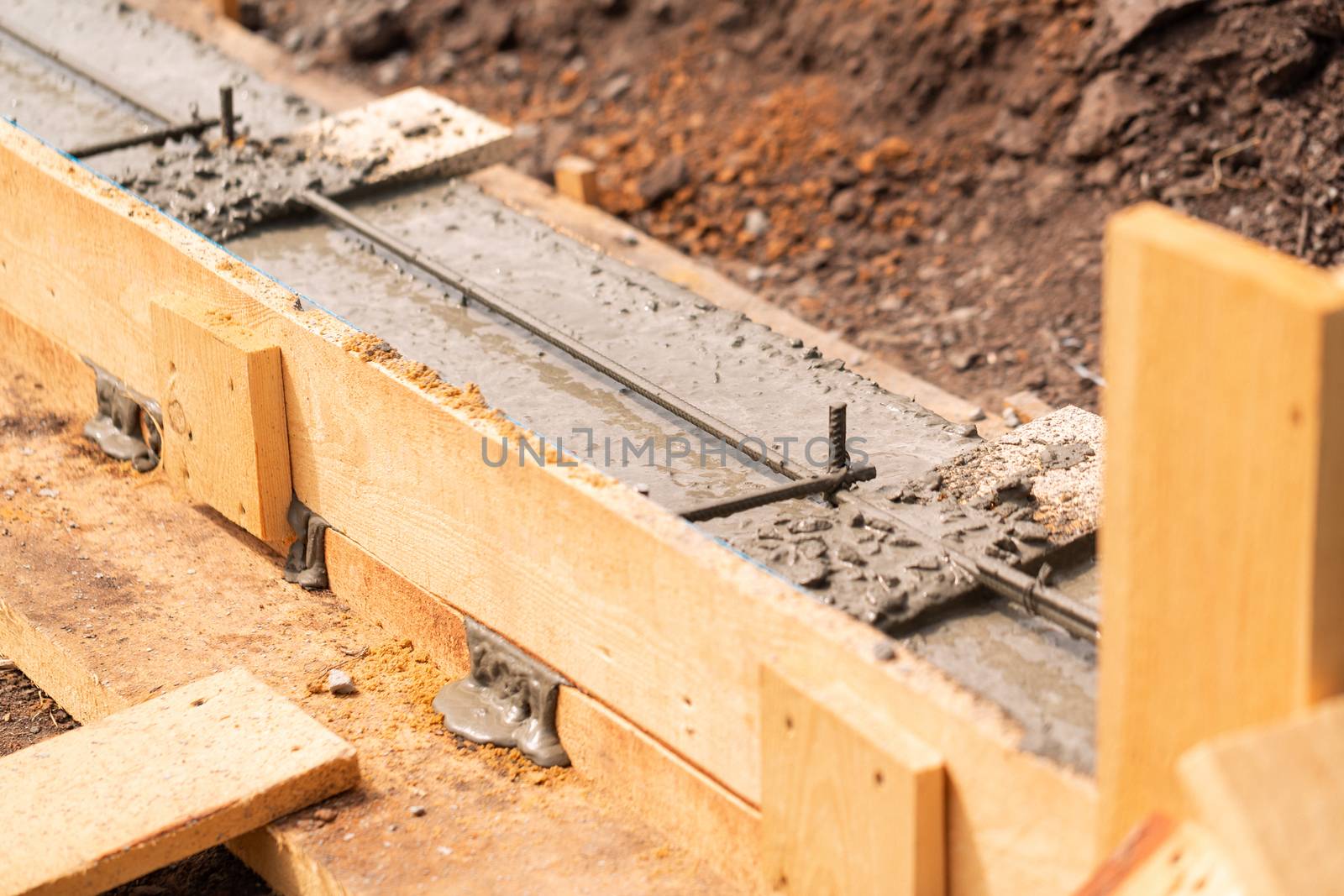 Lay of the cement or concrete into the foundation formwork with automatic pump. Building house foundation