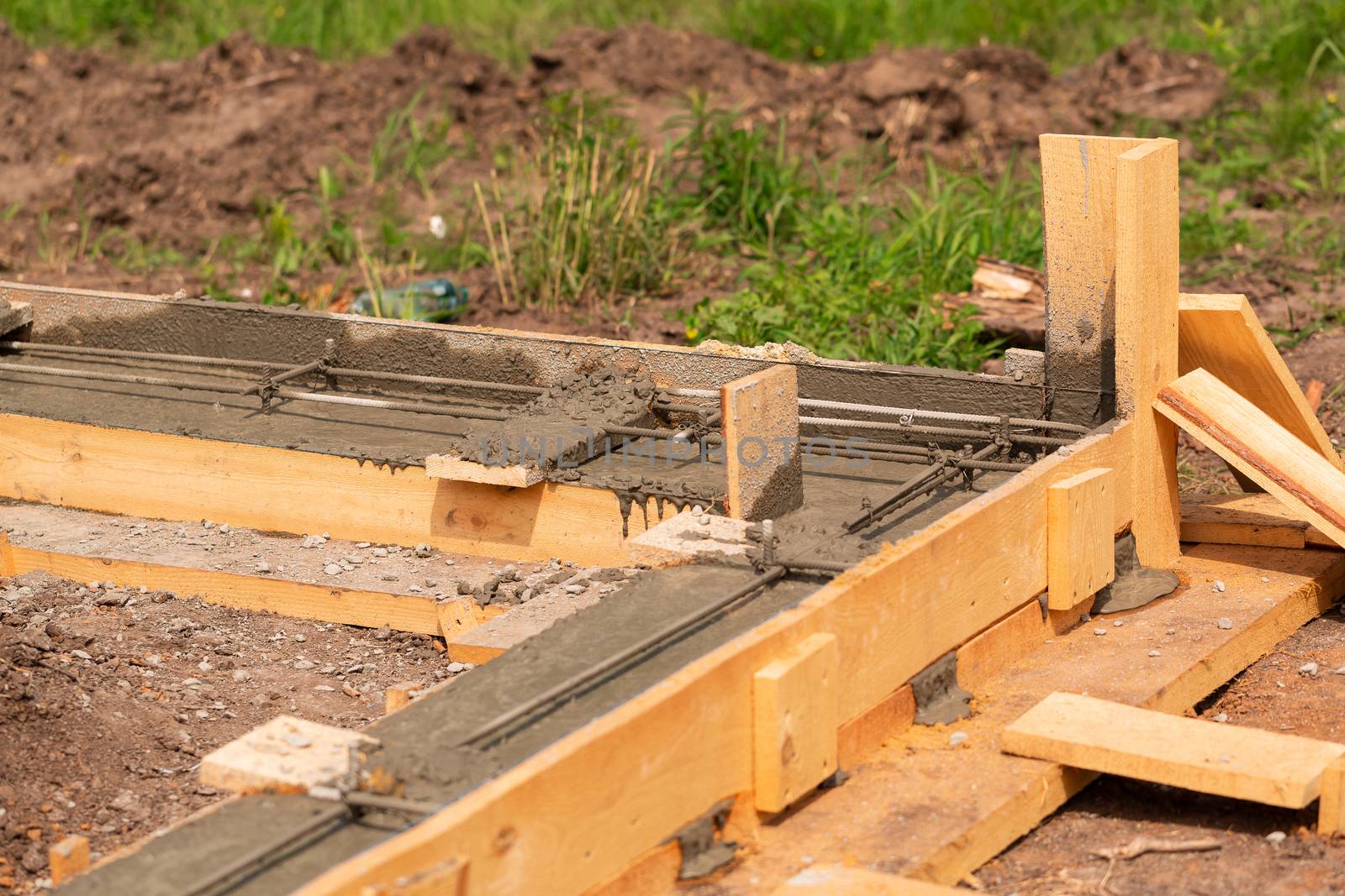 Lay of the cement or concrete into the foundation formwork with automatic pump. Building house foundation