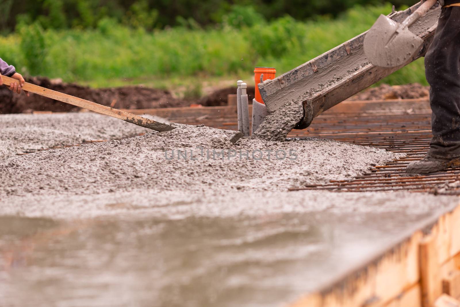 Lay of the cement or concrete into the foundation formwork from concrete mixer. Building house foundation