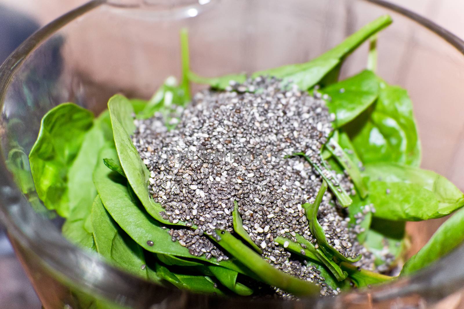 Healthy food. Chia seeds and spinach leaves mixed together in a bowl as ingredients.