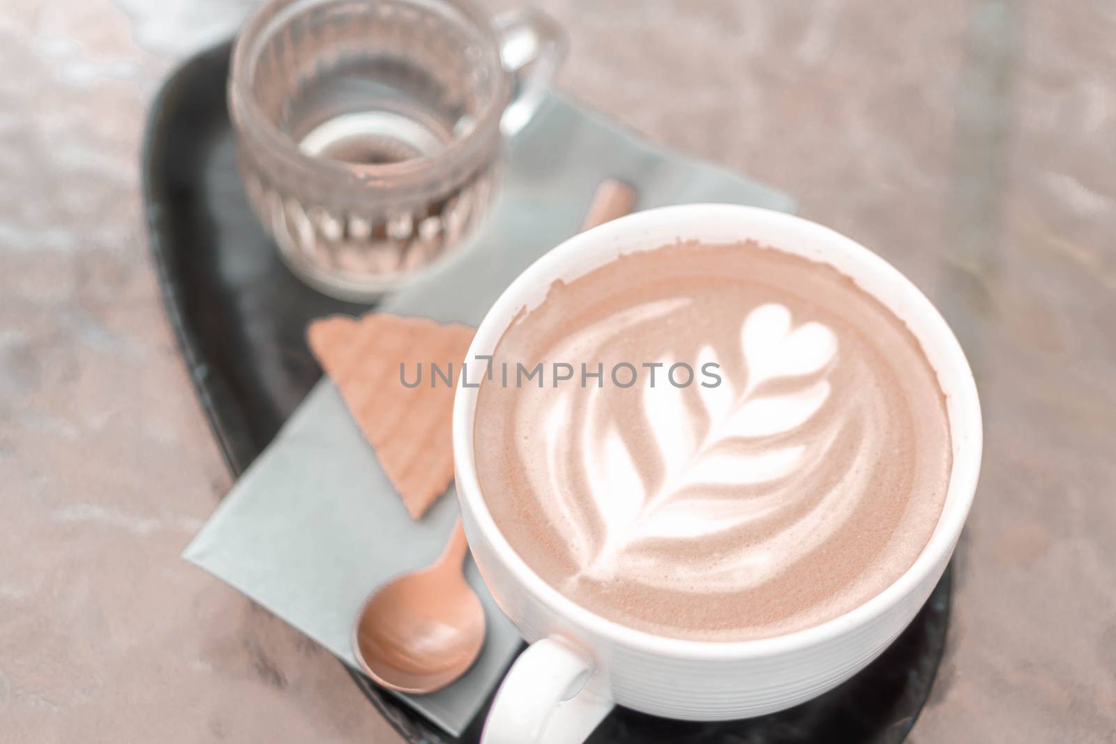 Closeup glass of latte art coffee tulip shape on wood background with vintage color, selective focus