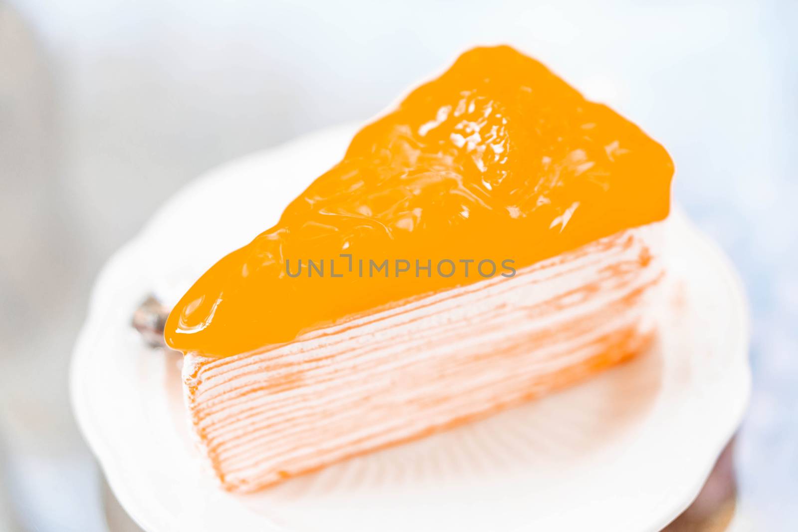 Closeup orange cake delicious on glass table background, selective focus