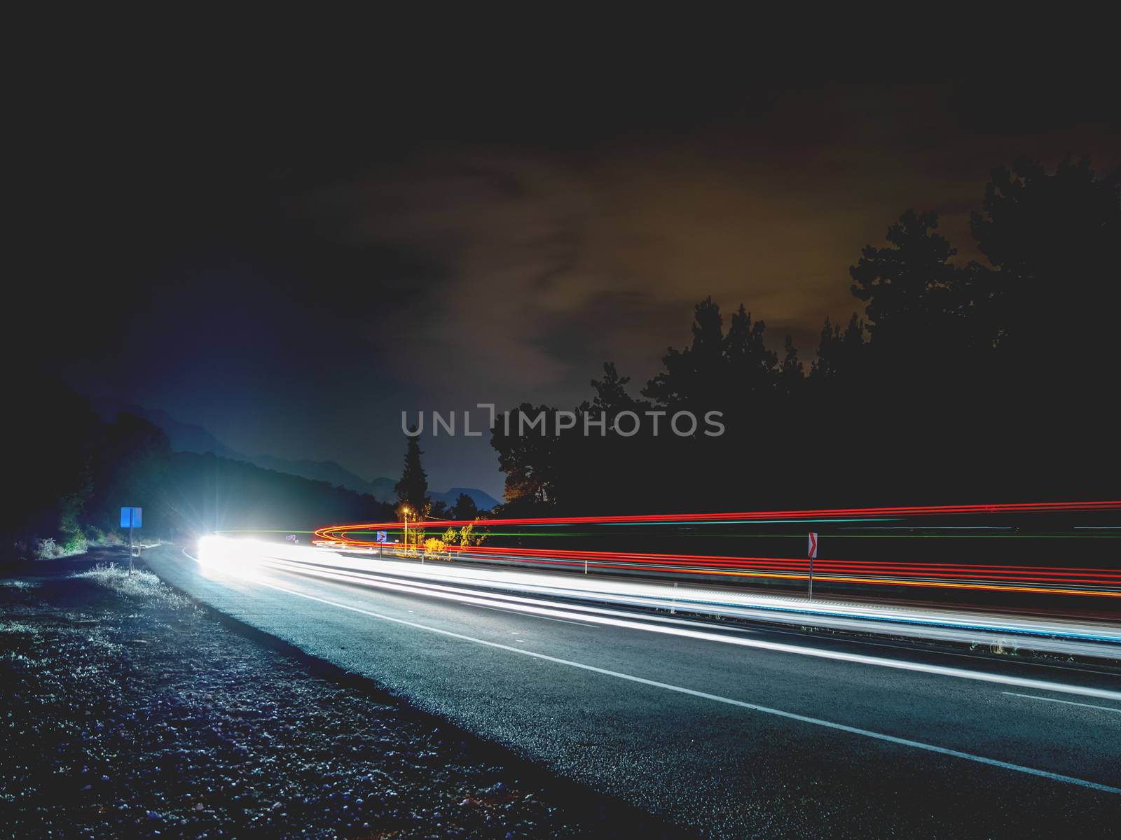 Motion blur photo of car going on road at night. Long exposure. Kemer, Turkey.