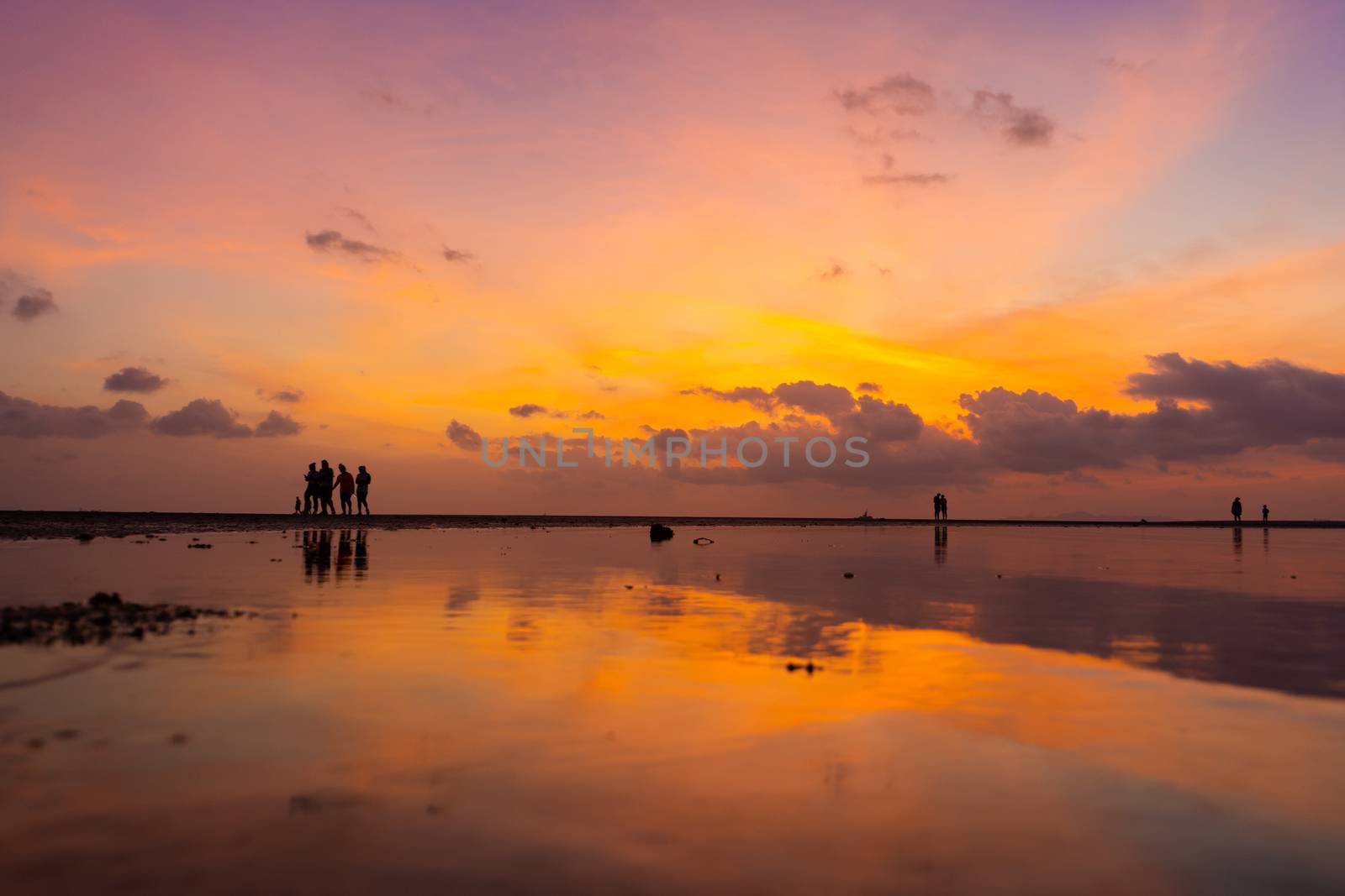 Burning bright sky during sunset on a tropical beach. Sunset during the exodus, the strength of people walking on water.
