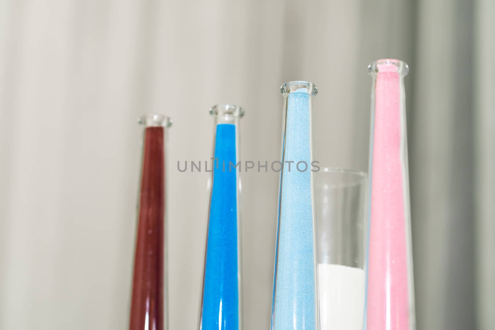 Stylish decorative glass colored vases for fresh flowers decorating the festive table