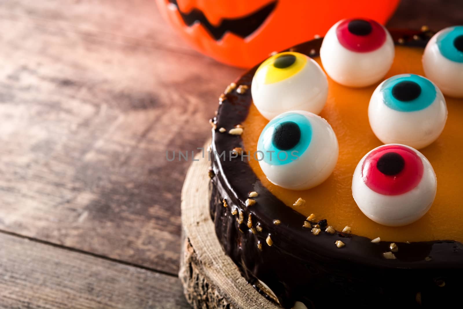 Halloween cake with candy eyes decoration on wooden table