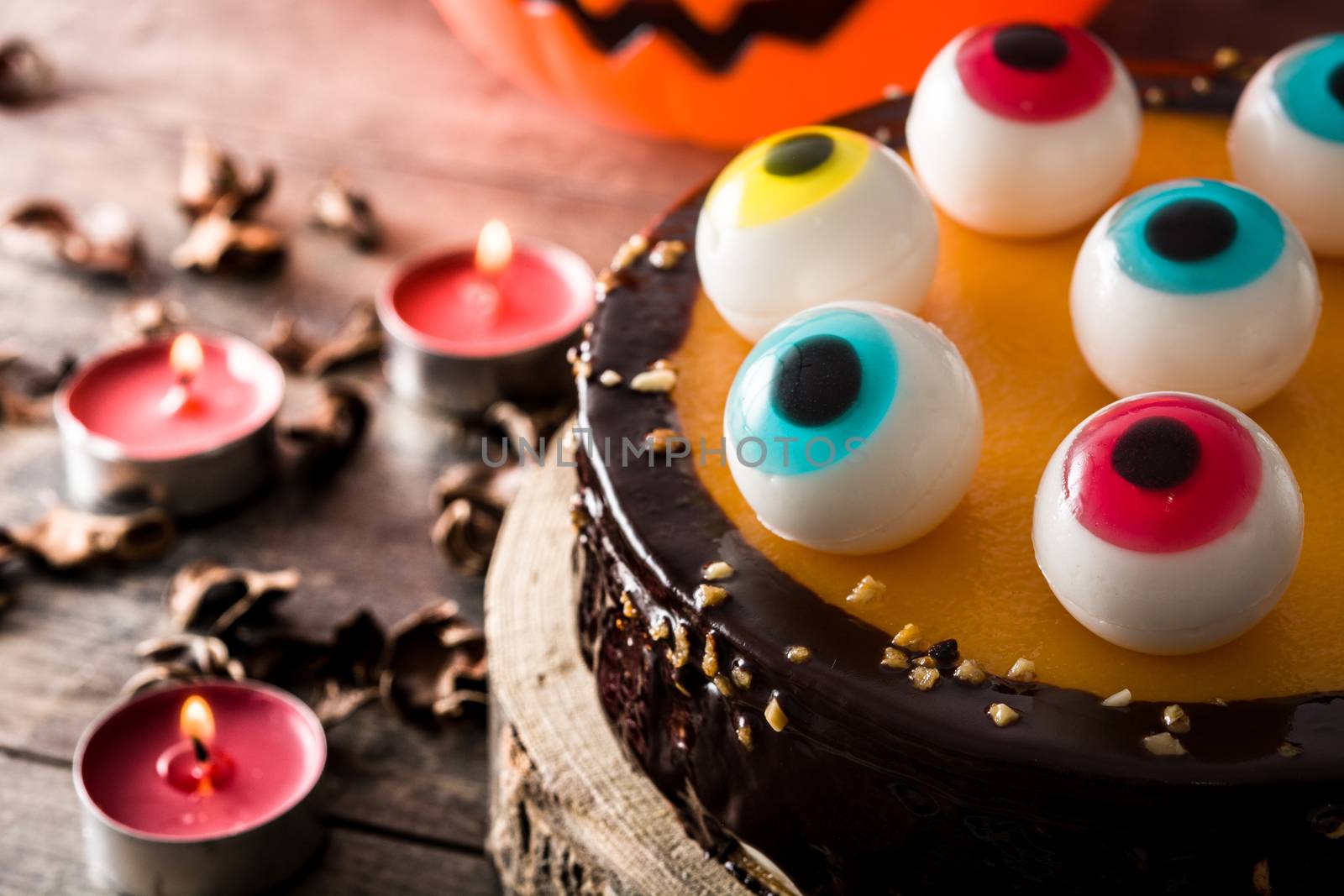 Halloween cake with candy eyes decoration on wooden table by chandlervid85