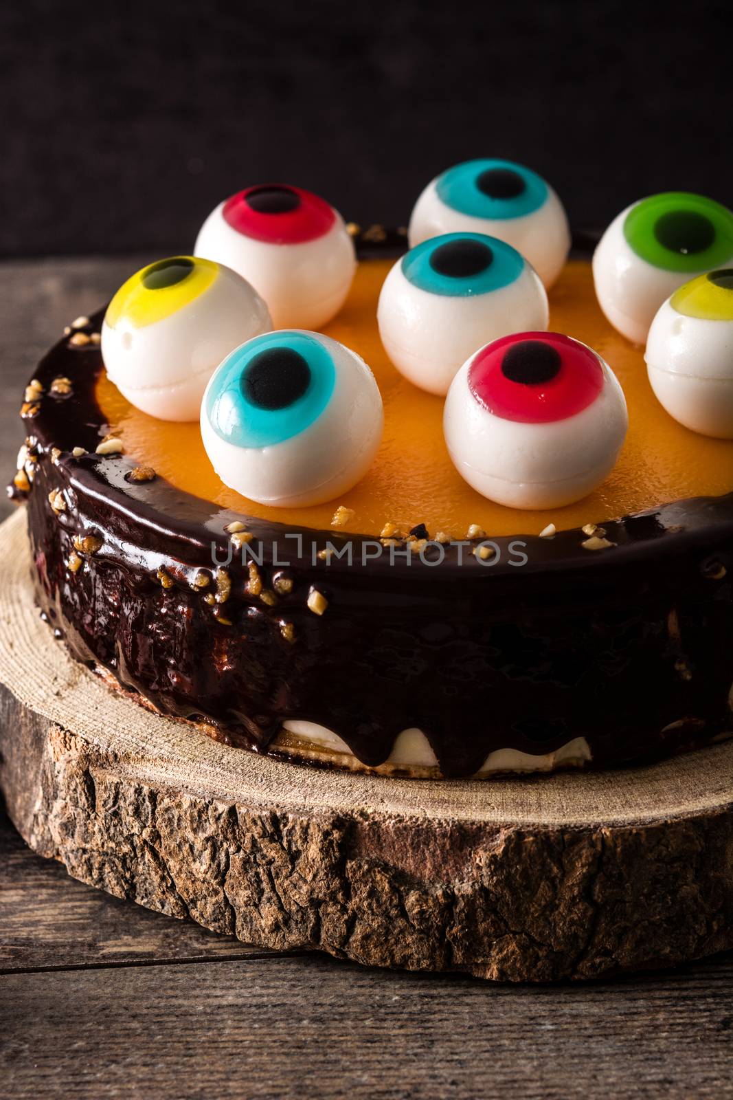 Halloween cake with candy eyes decoration on wooden table