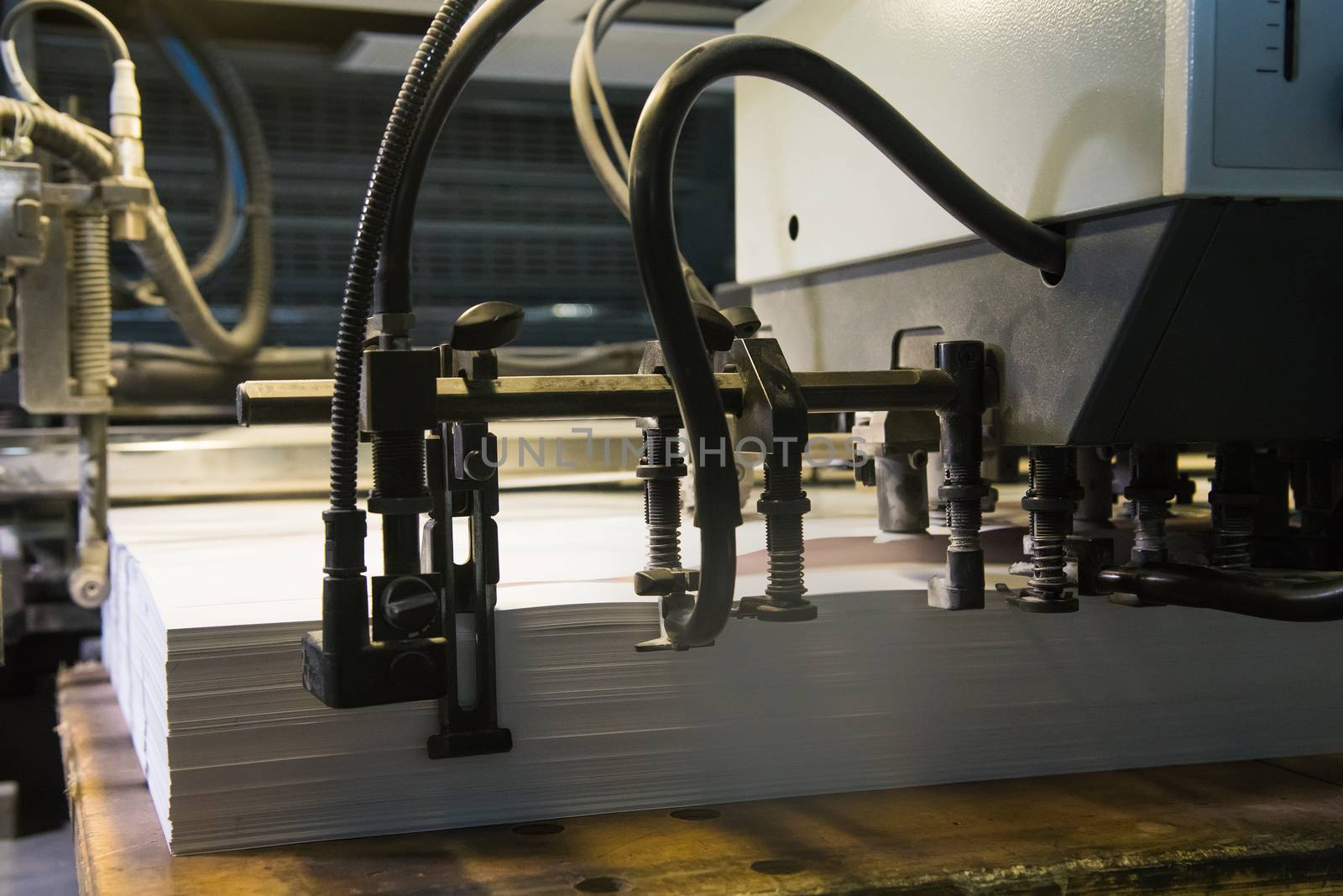 Printing presses at work in the printing. Printed sheets of paper are served in the printing press