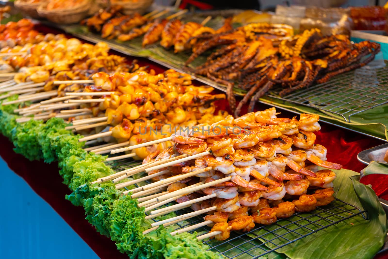 Street food market in Asia. Food counters, mini barbecue on a stick also called satey