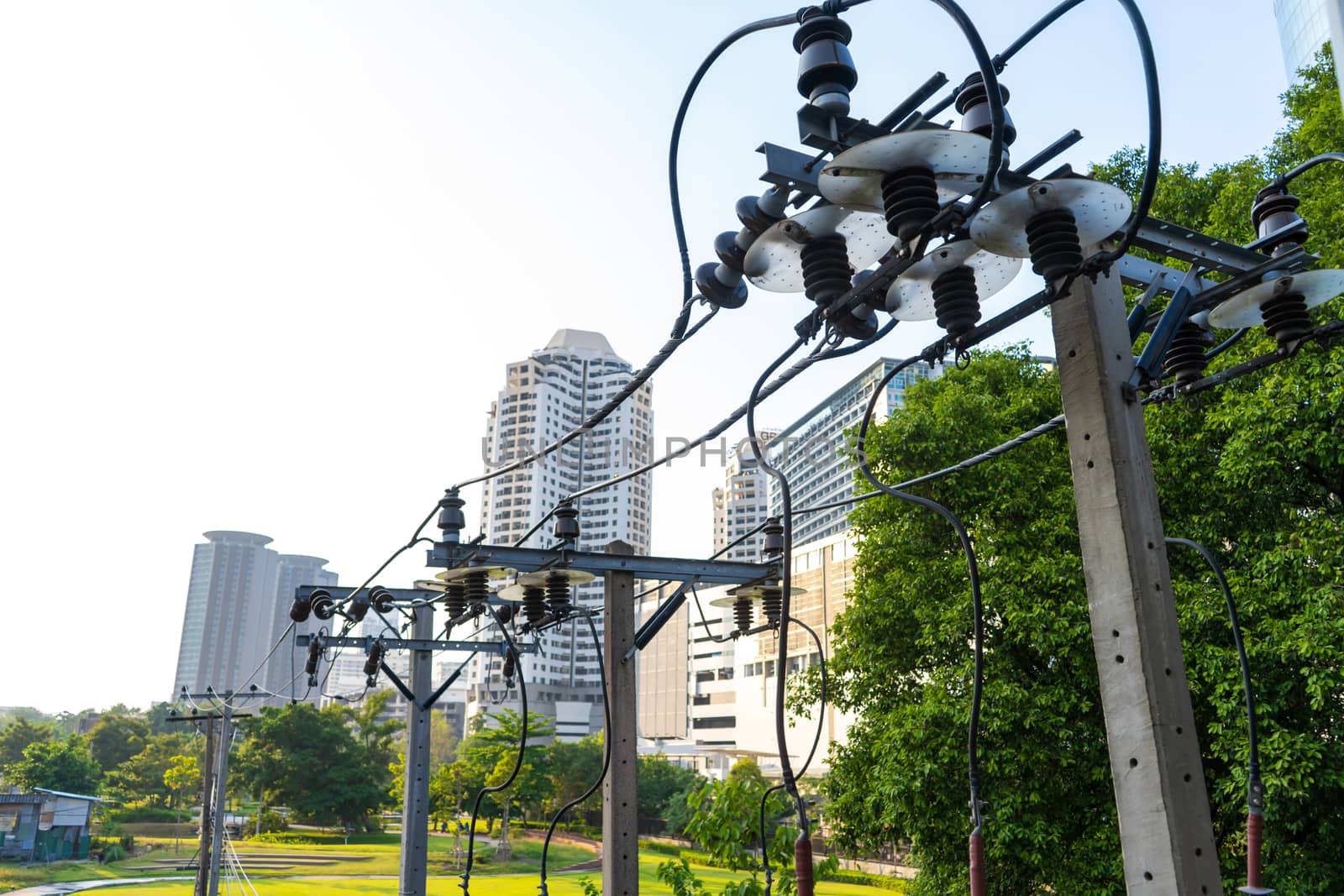 Pillars with wire power line against the background of the city.