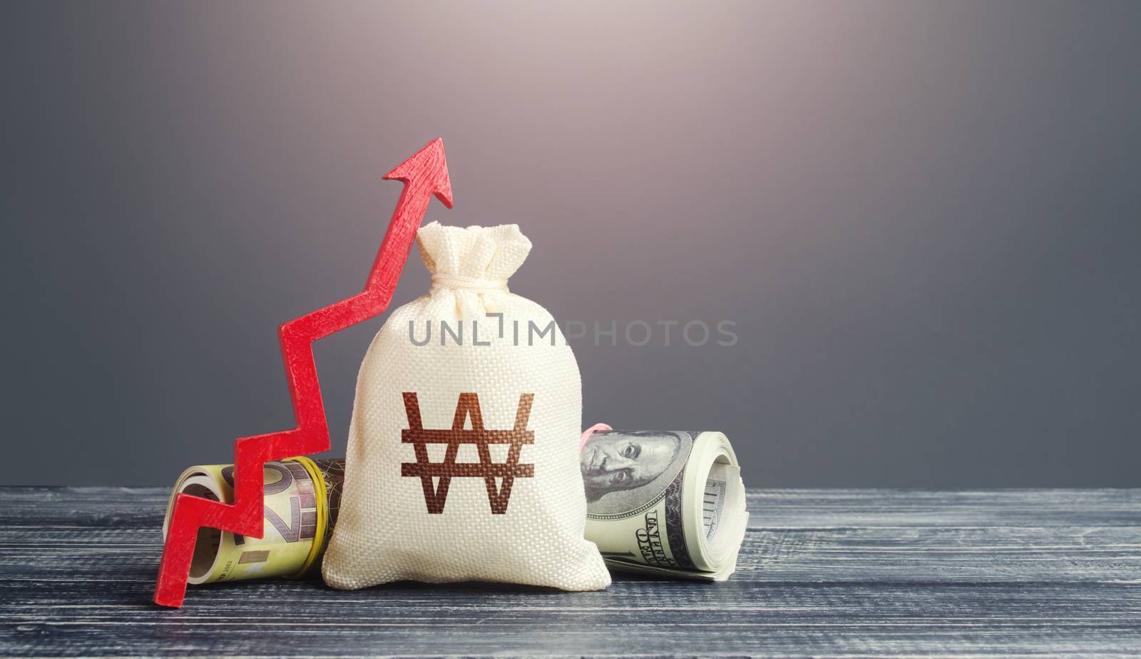 South Korean Won money bag and red arrow up. Growth of economy and increase of investment attractiveness. Stable currency. Developing markets. Rising inflation, money supply. Recovery. Reserve fund