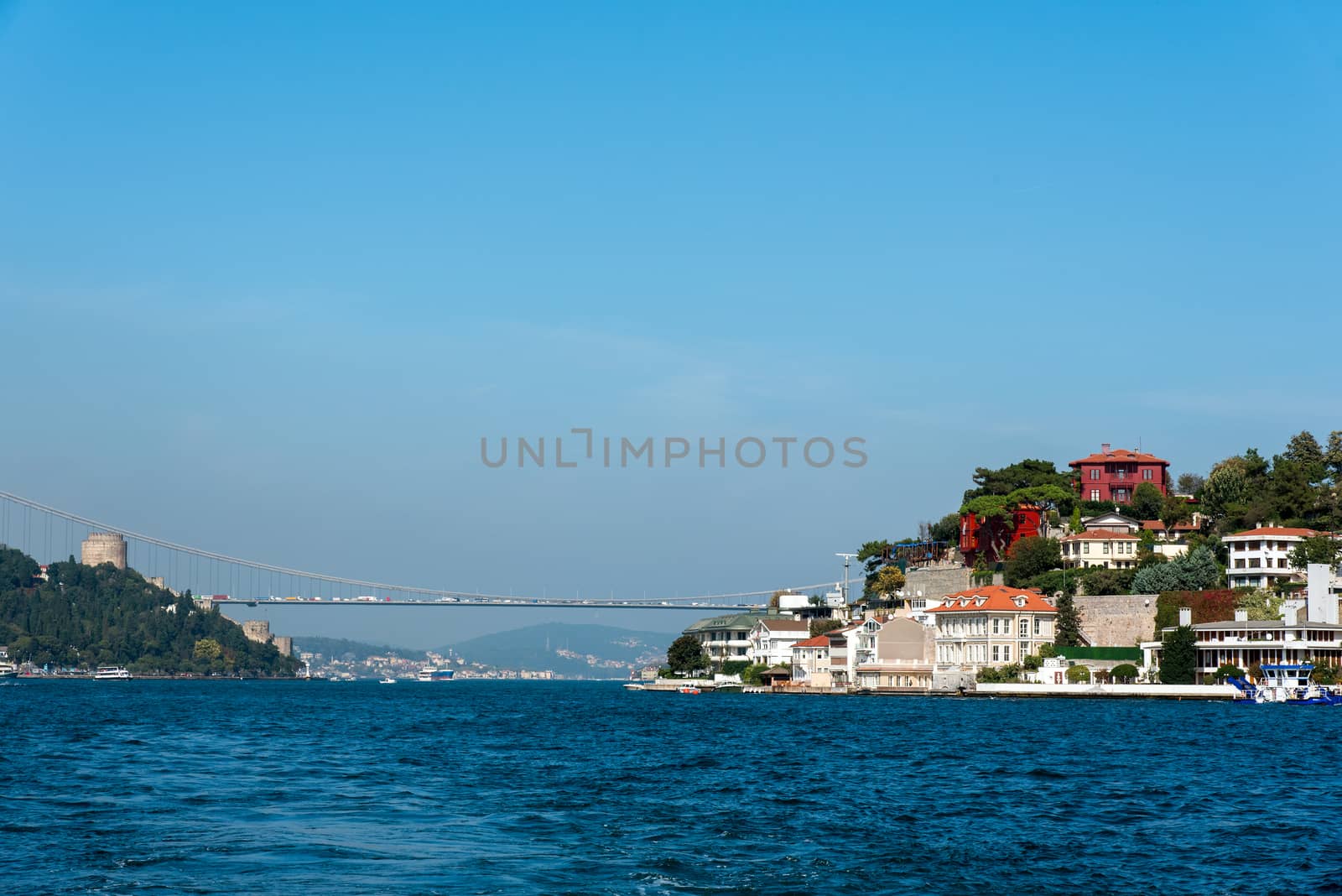 The Bosphorus in Istanbul with a houses at the shore and the second Bosphorus Bridge in the distance