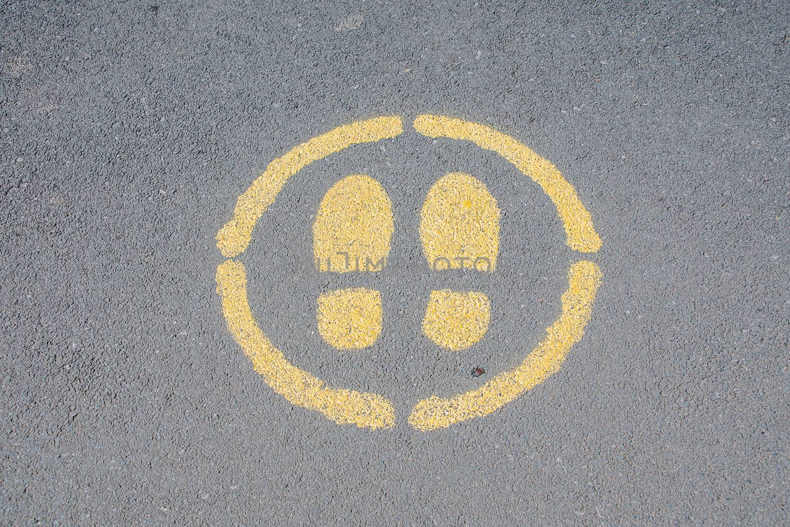 Sign painted on a pavement indicating where to stand
