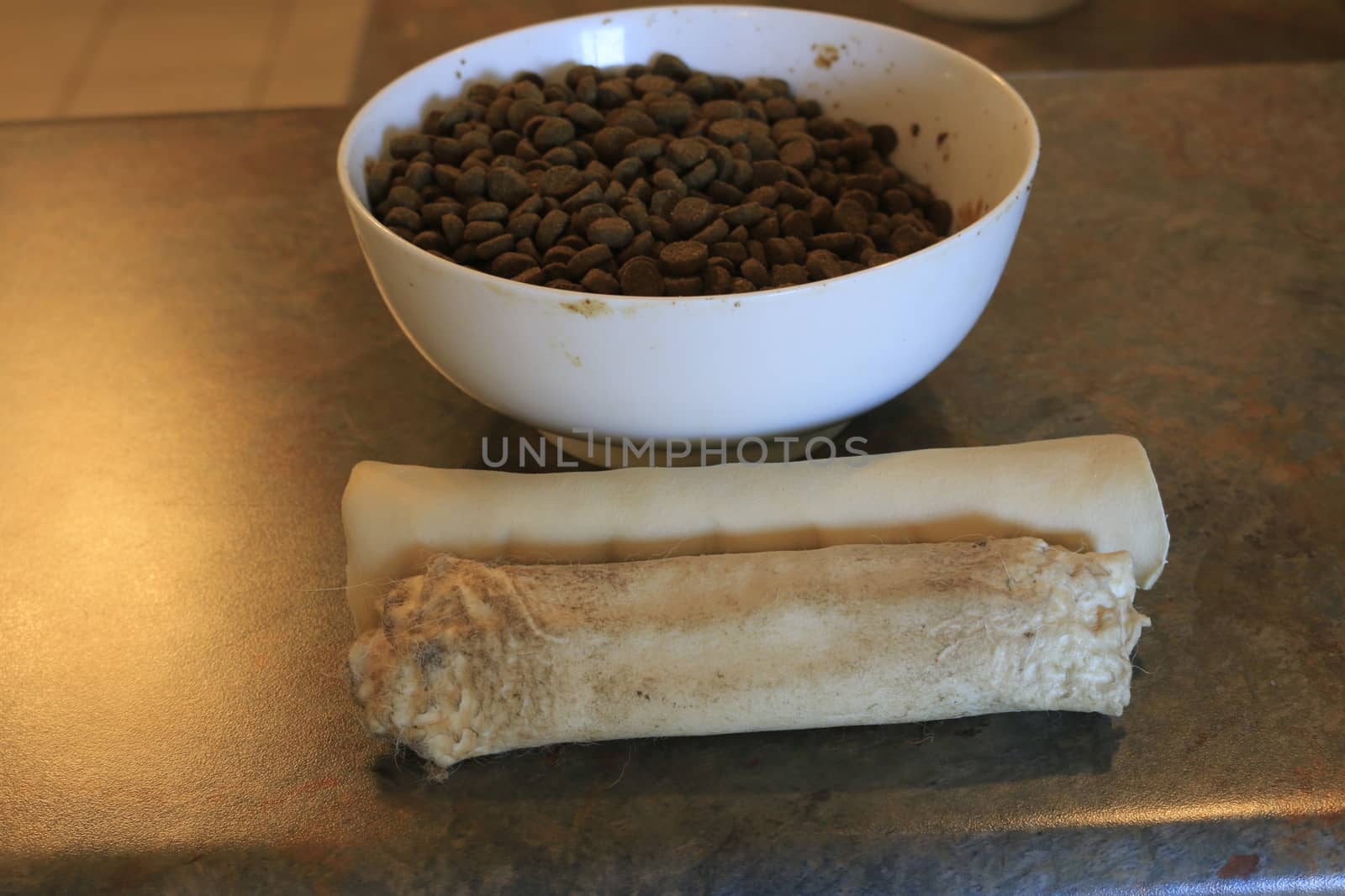 Rawhide chew next to dog kibble. Theme of controversial dog food. by mynewturtle1