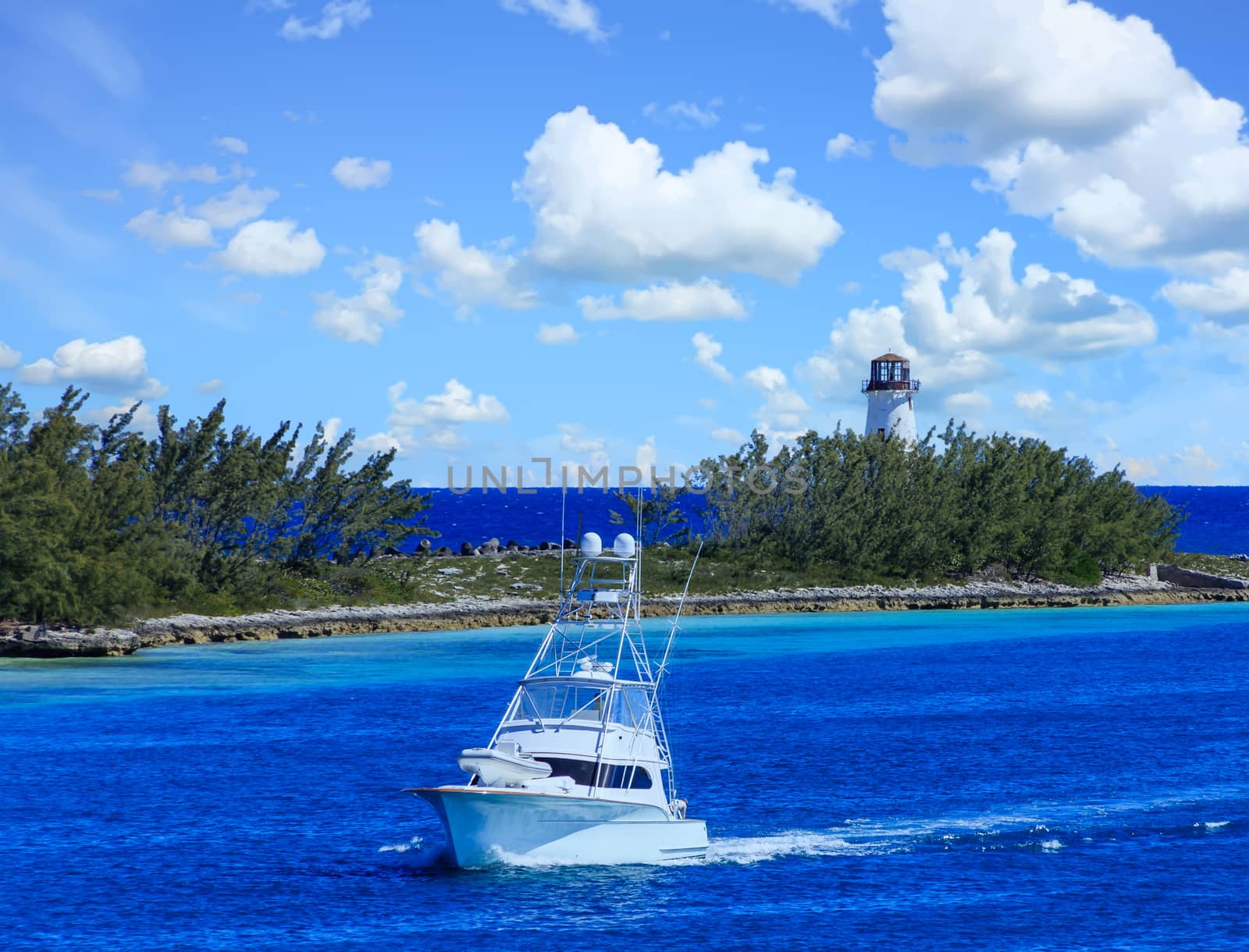 A Fishing Boat Entering a Channel by a Lighthouse in Nassau Bahamas