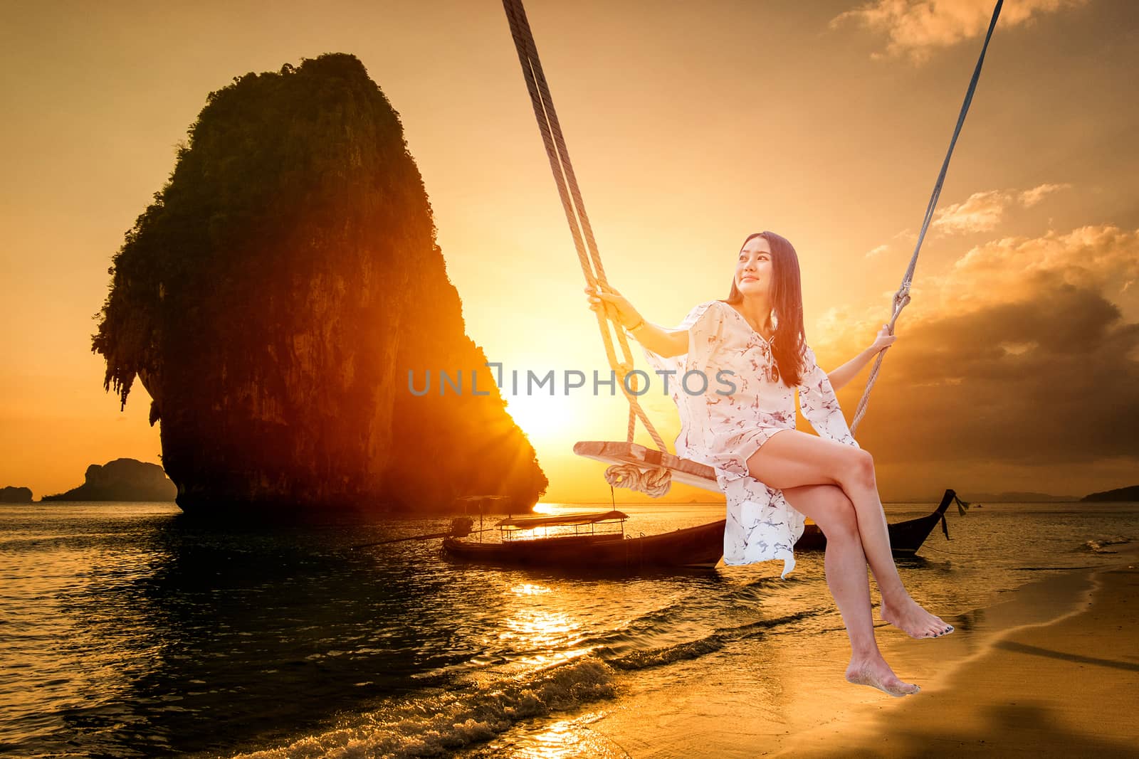 Beautiful woman sitting on a swing on the beach  in Krabi, Thail by Surasak