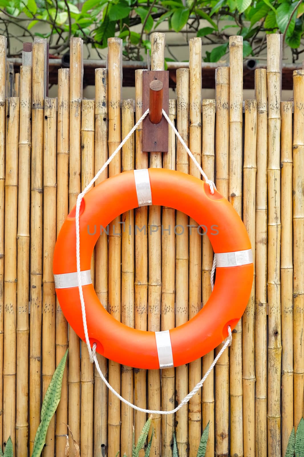 Life buoy hanging on bamboo wall for emergency  by Surasak
