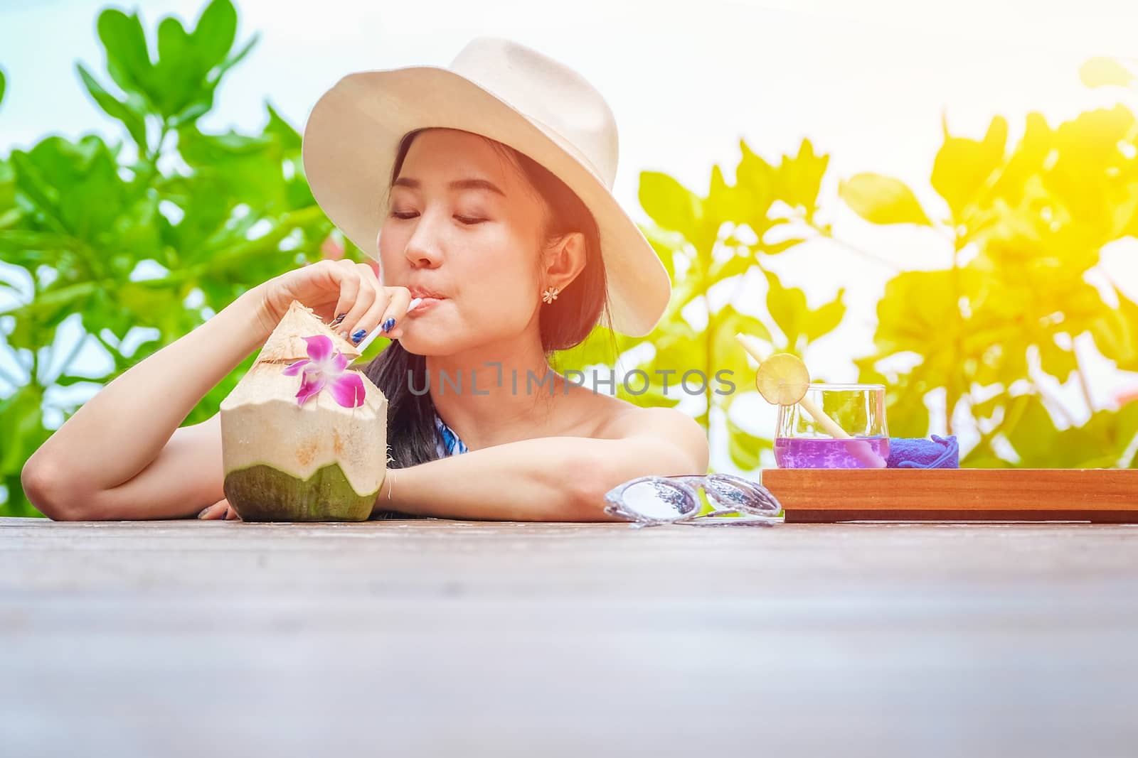 Happy woman with fresh coconut water on the beach