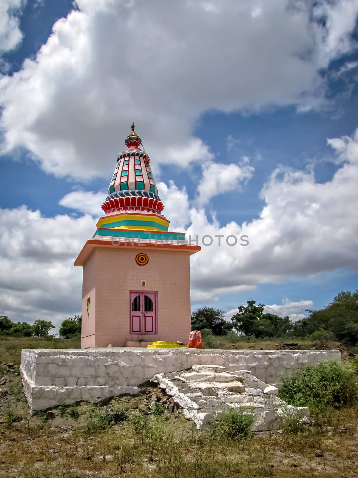 On the background of nice clouds, photo of Colorful isolated image of a temple in the outskirts of village.