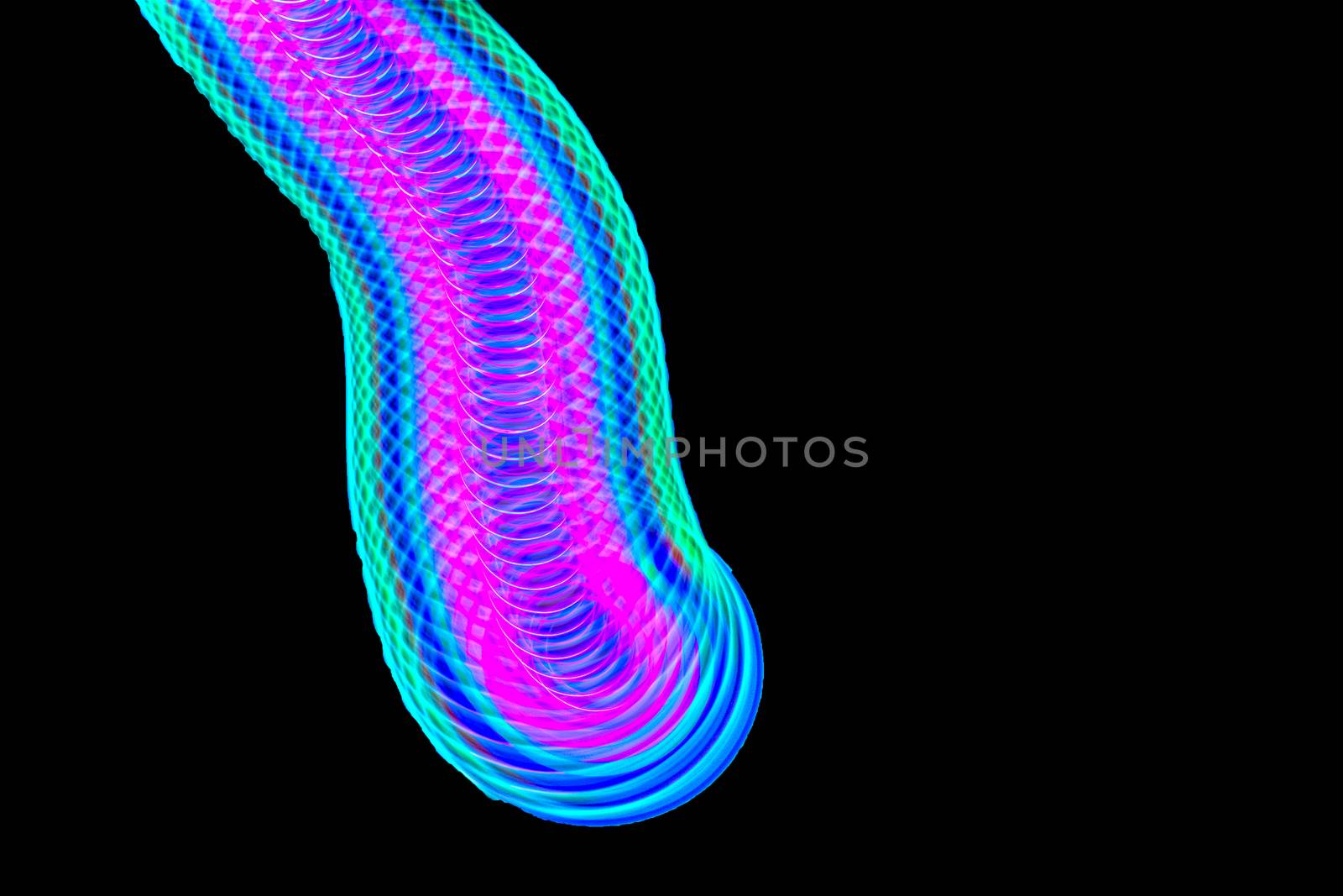Long exposure photograph of a light spinning top with black background.