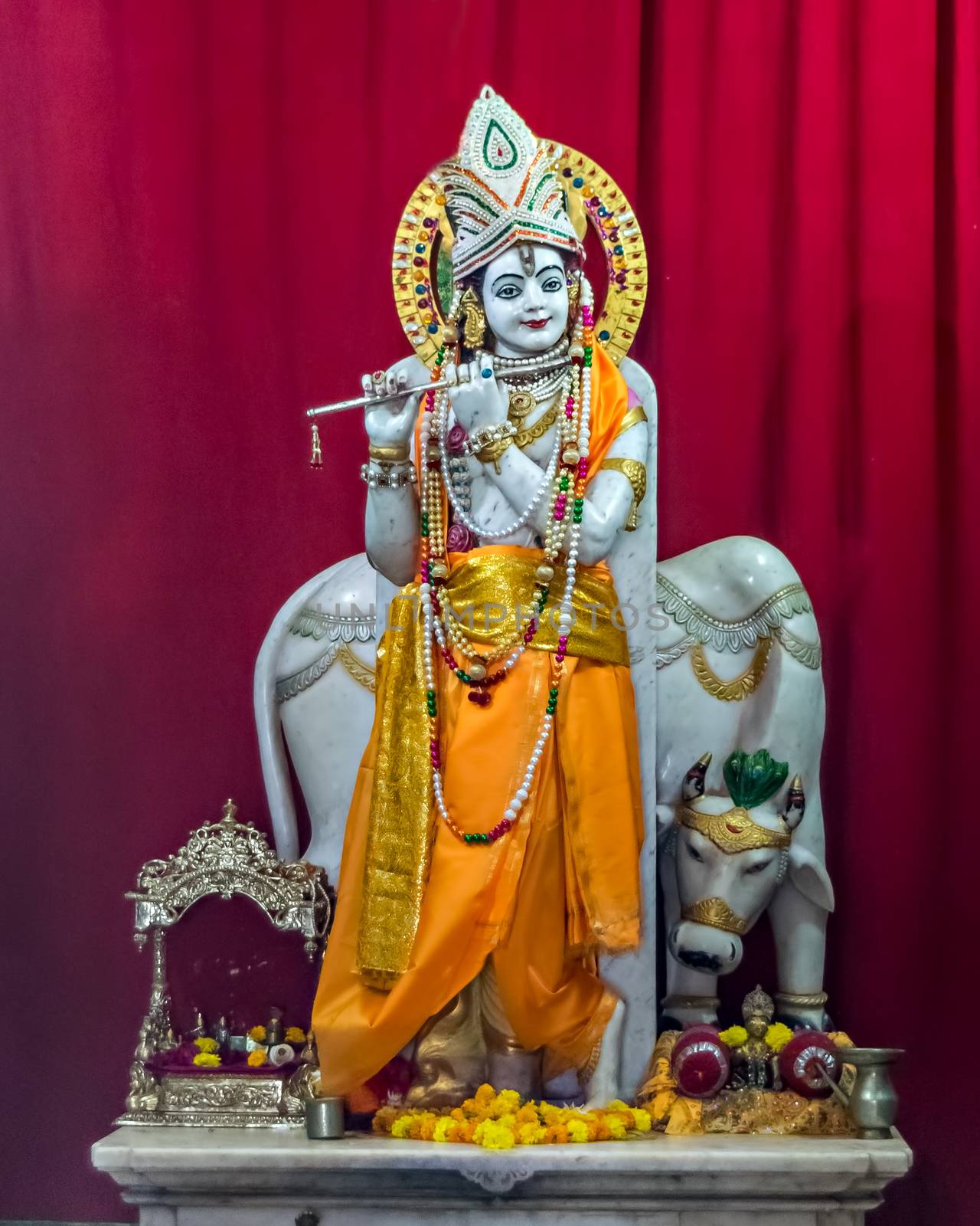 Nicely carved and decorated isolated idol of Hindu God Krisna with flute in a temple at Somnath, Gujrat, India. by lalam