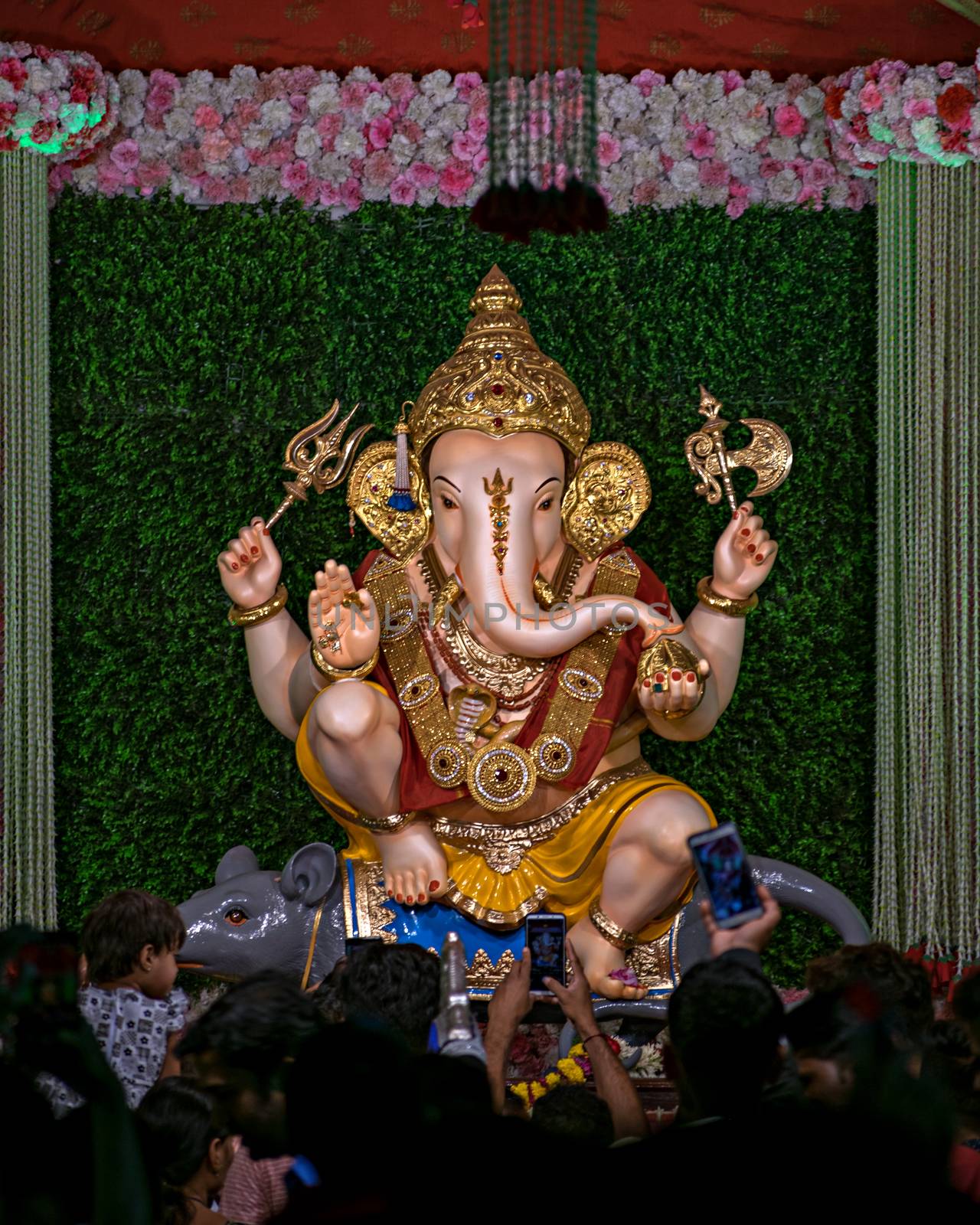 Close up portrait view of decorated and garlanded  idol of Hindu God Ganesha in Pune ,Maharashtra, India. by lalam