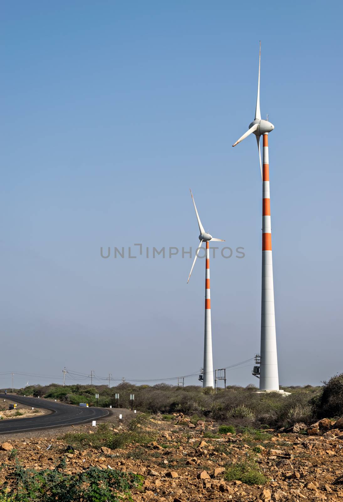 Windmills for electricity generation  near a highway in Dwarka, Gujrat, India.