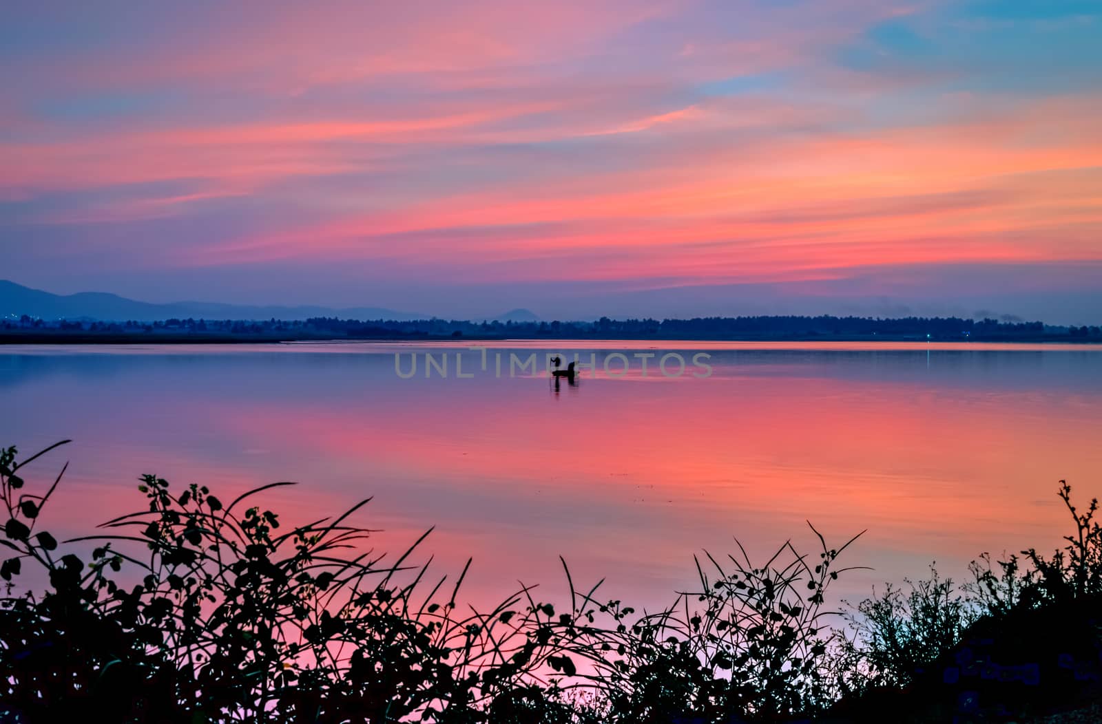 Beautiful evening sky over a lake in Hampi, Karnataka, India with nice dusk colors in the sky and lake.