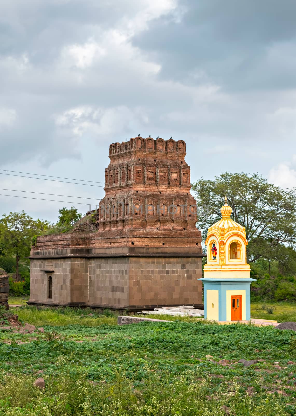 Small , colorful temple and landscape in village Ambale, Maharashtra, India. by lalam