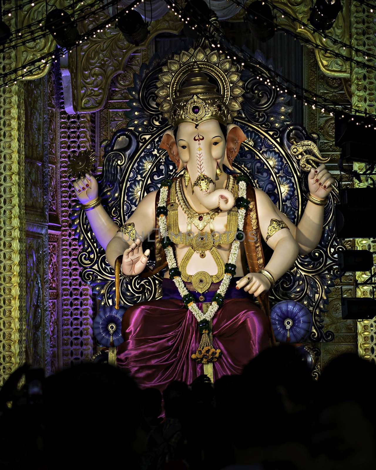 Closeup , portrait view of decorated and garlanded  idol of Hindu God Ganesha in Pune ,Maharashtra, India. by lalam