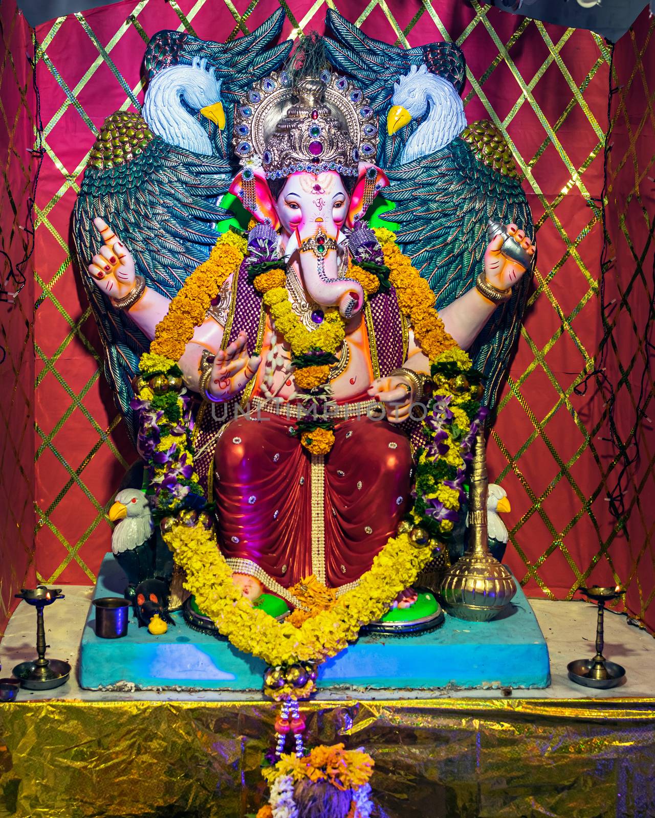 Closeup , portrait view of decorated and garlanded  idol of Hindu God Ganesha in Pune ,Maharashtra, India.