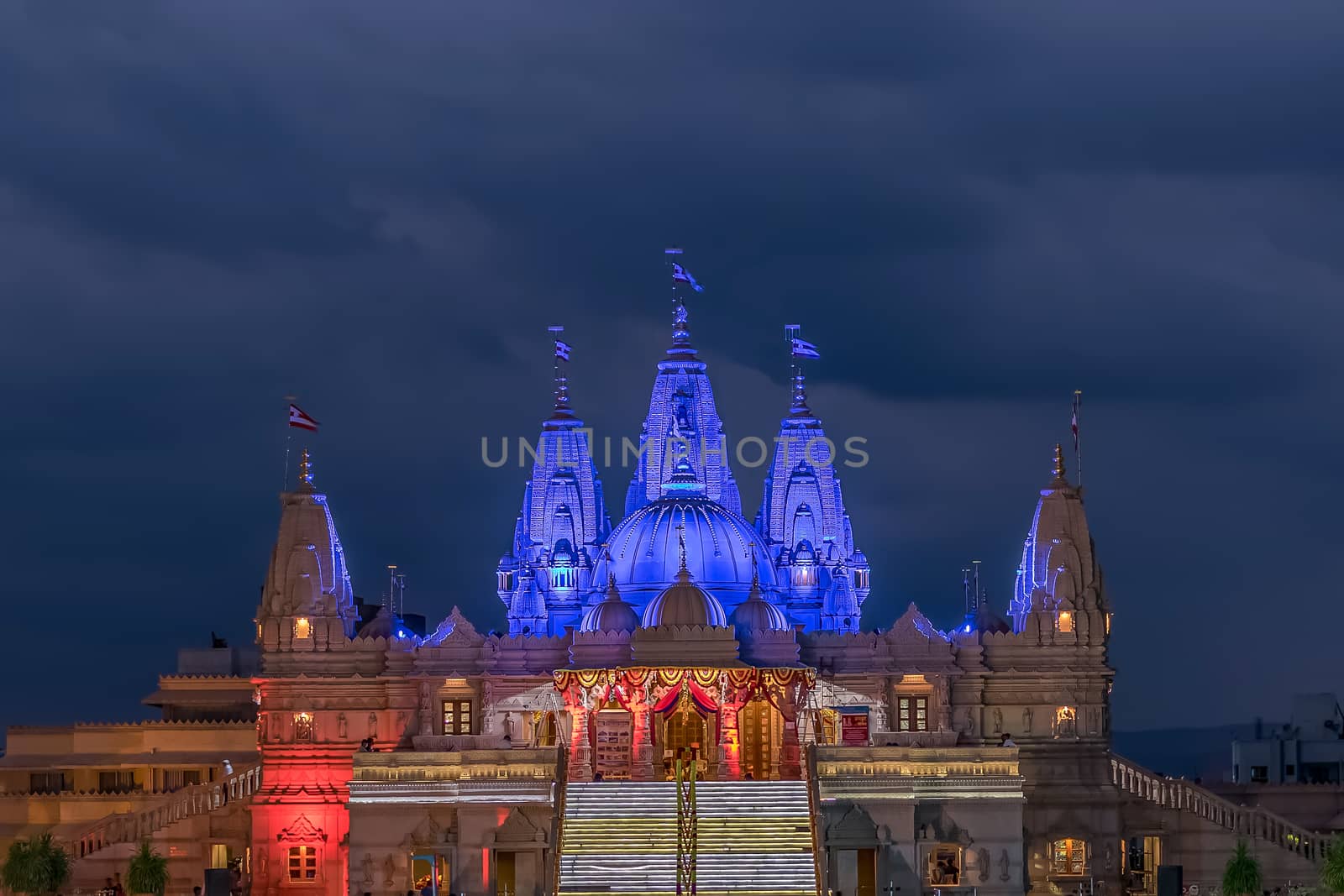 Lighted image of Shree Swaminarayan temple with monsoon clouds background, Ambe Gaon,  Pune . by lalam