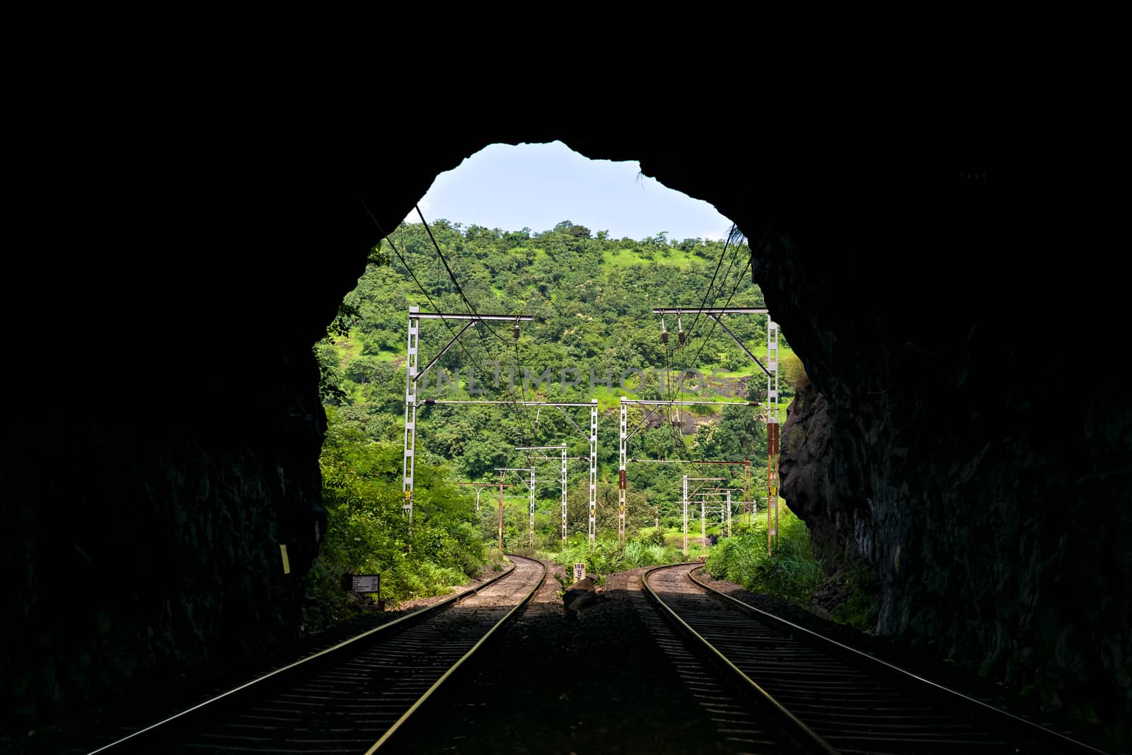 Photograph of view through a railway tunnel with tow diverging routes ahead.