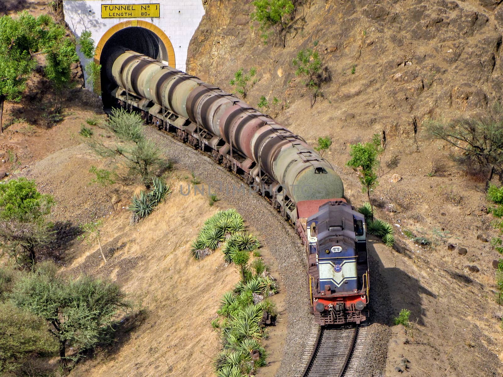 Diesel locomotive hauling a tanker rake through a tunnel on a railway line. by lalam